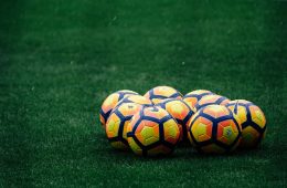 pile of yellow-orange-and-red Nike soccer balls